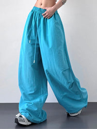 Turquoise wide-leg pants worn by a person on a plain background