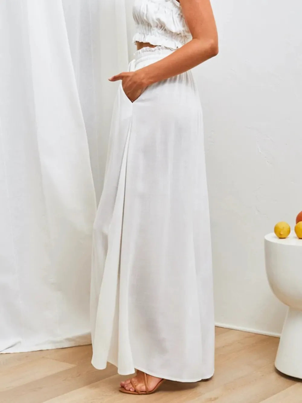 Person wearing a white dress with a plain background