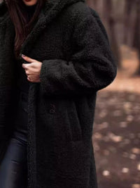 Person wearing a dark coat in a forest setting