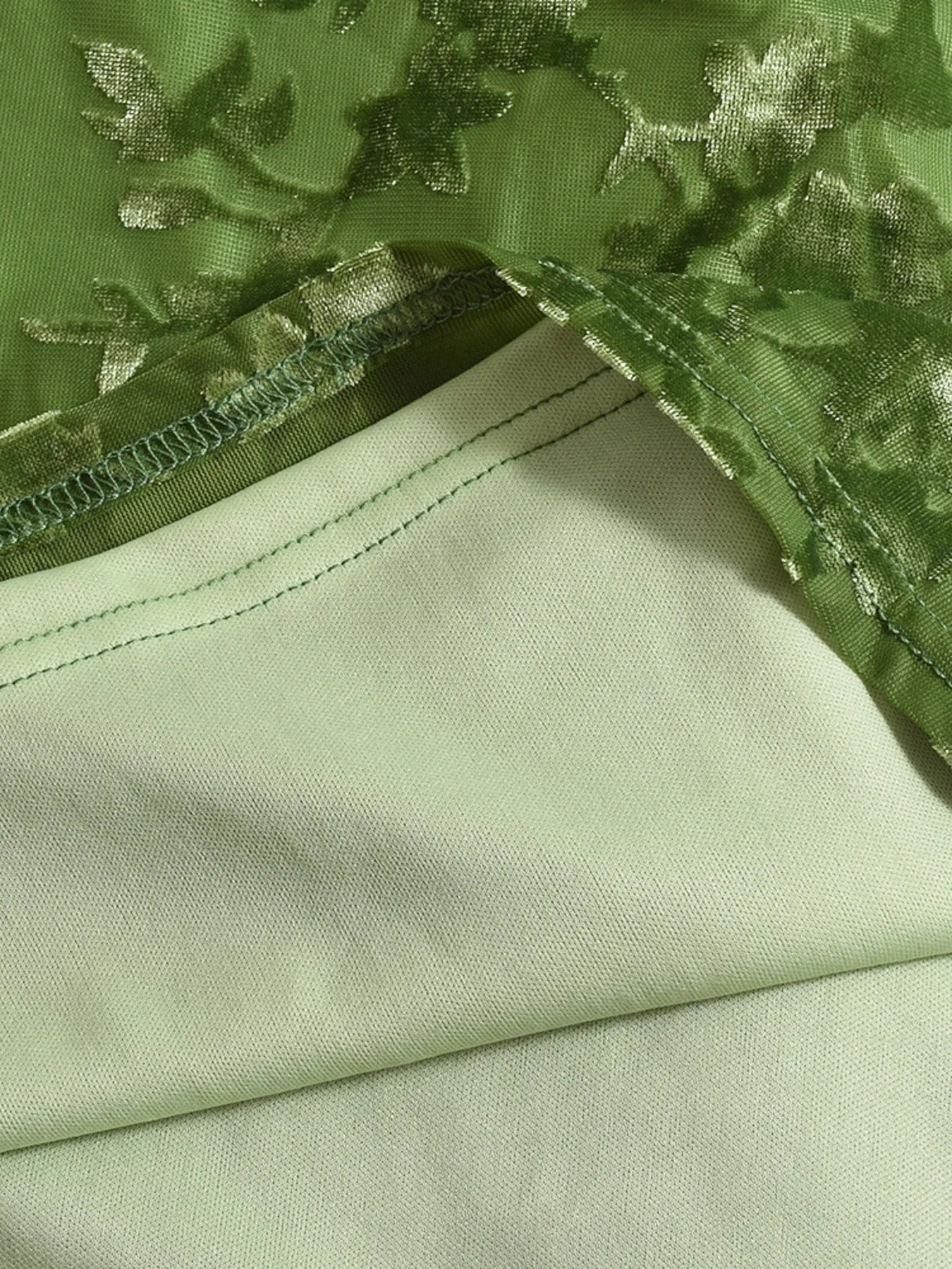 Close-up of green fabric with floral embroidery