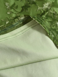 Close-up of green fabric with floral embroidery