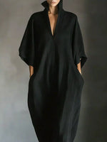 Person wearing a black dress against a gray background