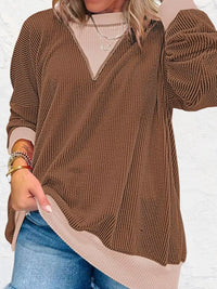Brown sweater with beige collar and cuffs worn by a person on a white background