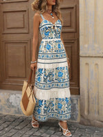 Woman wearing a floral dress standing in front of a wooden door.