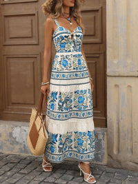 Woman wearing a floral dress standing in front of a wooden door.