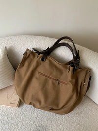 Brown handbag on a textured surface with a neutral background