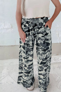 Camouflage pants worn by a person against a white background
