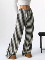 Black and white striped pants worn by a person on a white background