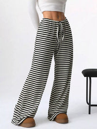 Black and white striped pants worn by a person on a white background
