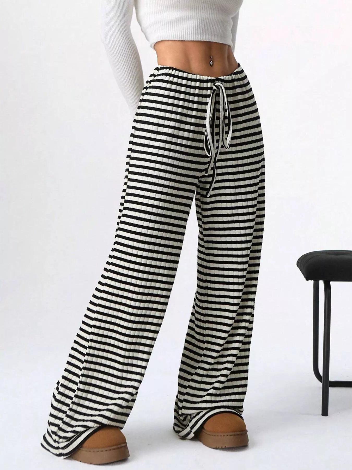 Black and white striped pants worn by a person on a white background