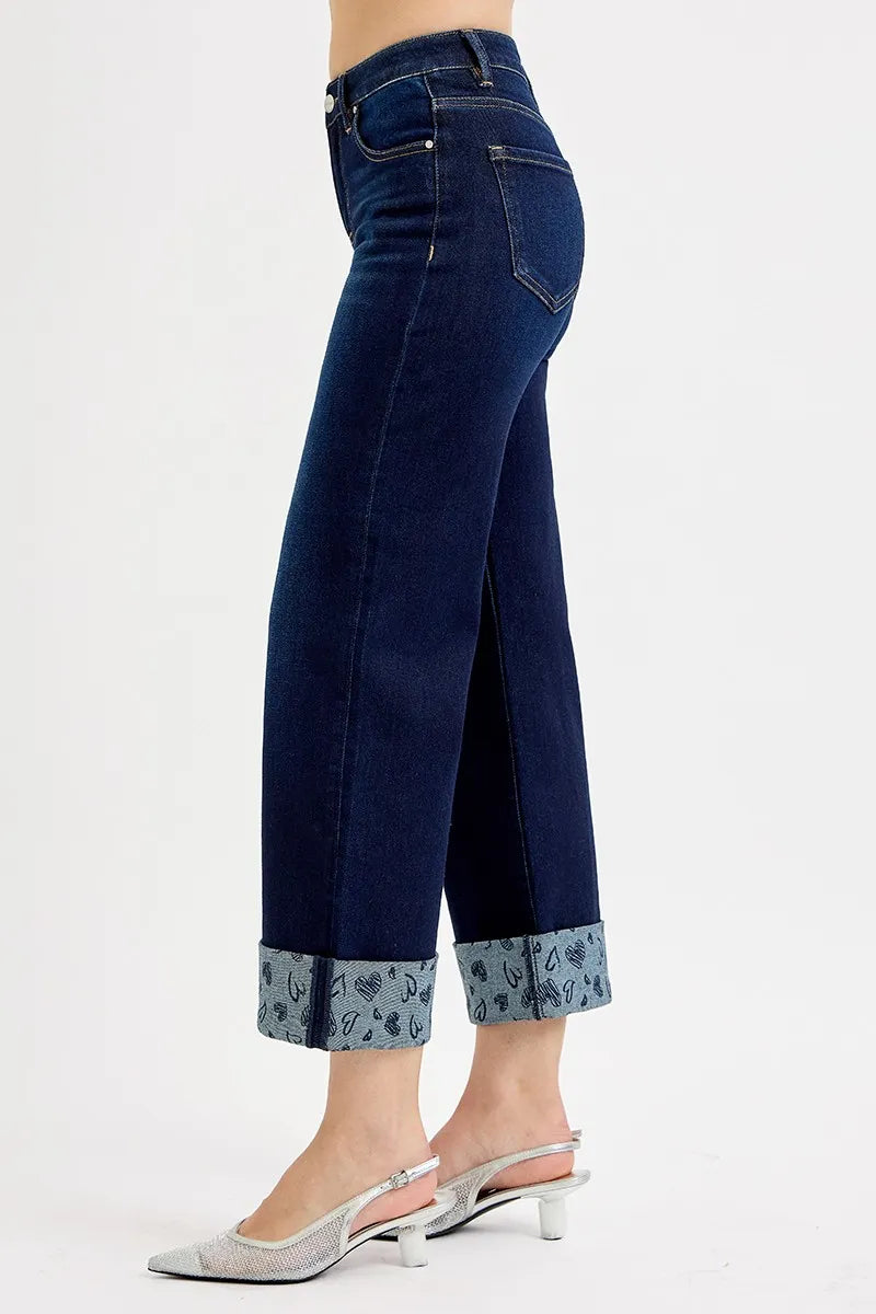 Dark blue jeans with floral cuffs on a white background