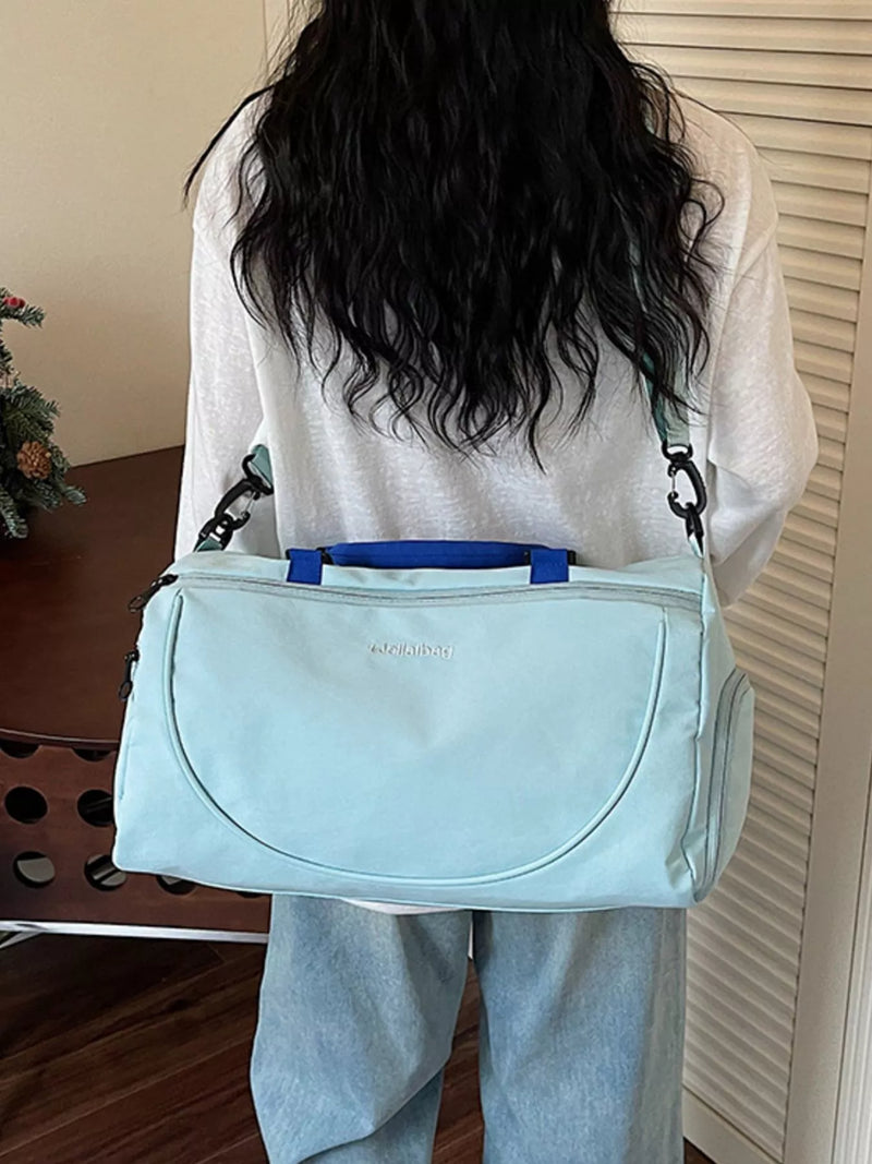 Person holding a light blue bag with a visible brand name.