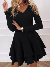 Black long-sleeve dress worn by a person on a white background