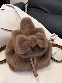 Brown fur backpack on a white surface with a black chair in the background