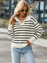 Woman wearing a black and white striped sweater with light blue jeans outdoors.