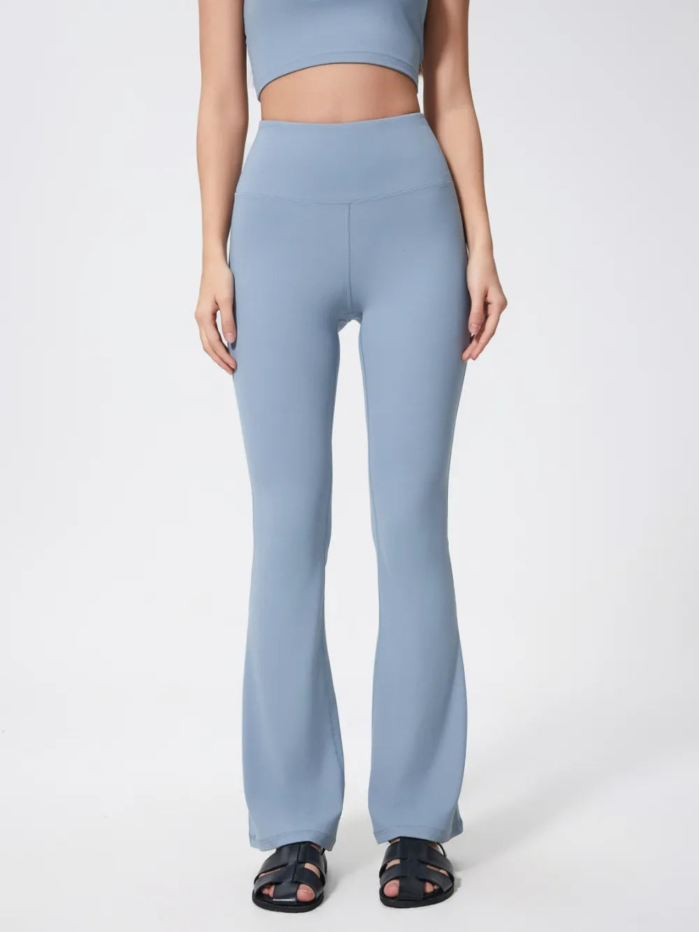 Person wearing light blue high-waisted pants on a white background