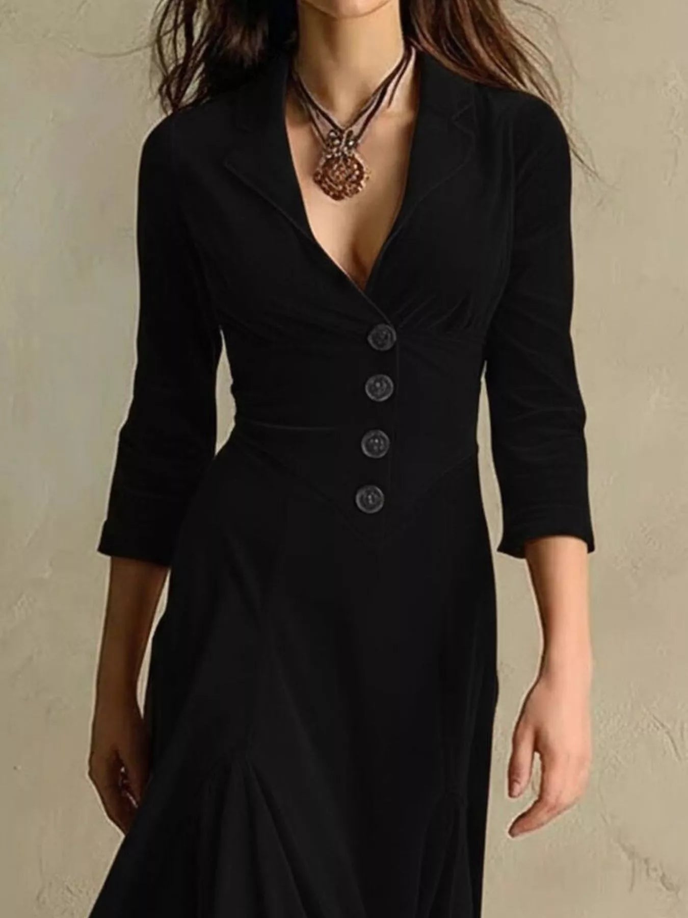 Black dress with buttons on a neutral background
