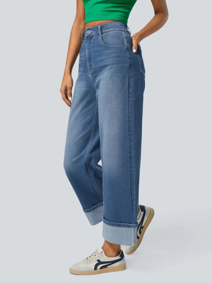 Person wearing blue jeans and a green top on a white background