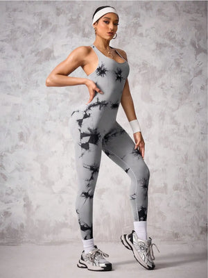 Woman wearing a gray and black patterned jumpsuit against a gray background