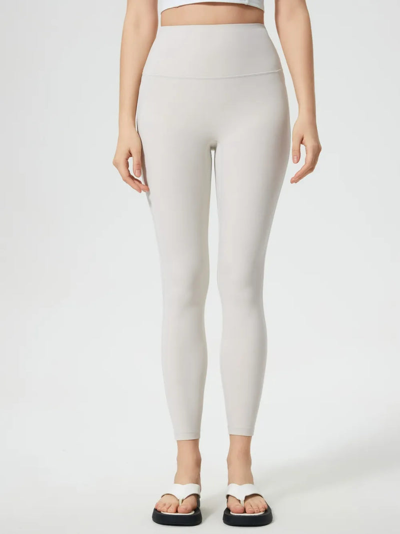 Person wearing beige leggings on a white background