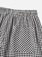 Close-up of black and white gingham checkered fabric with an elastic waistband and a front patch pocket.