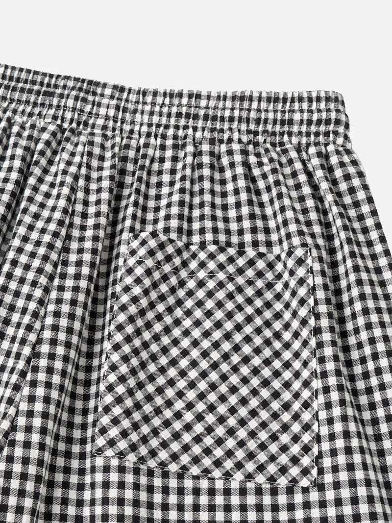 Close-up of black and white gingham checkered fabric with an elastic waistband and a front patch pocket.