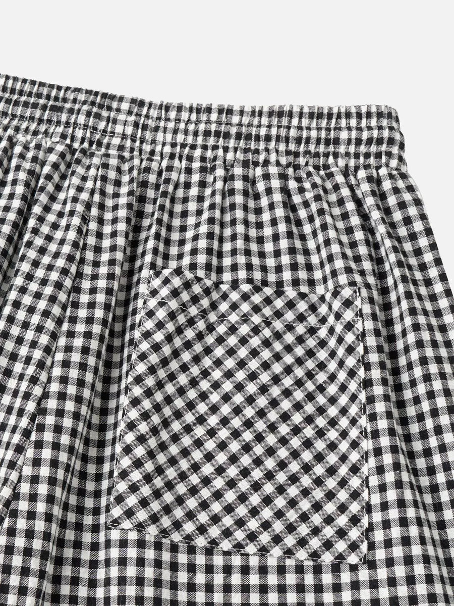 Close-up of black and white gingham checkered fabric with an elastic waistband and a front patch pocket.