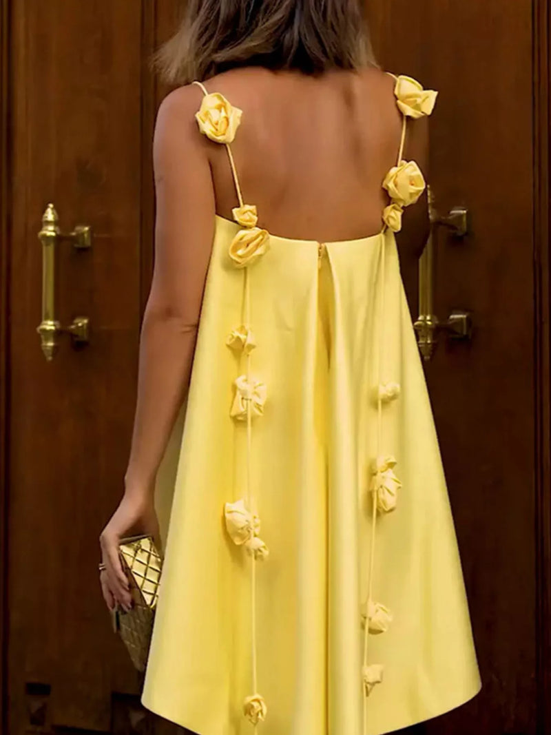Yellow dress with floral details on straps against a wooden door background