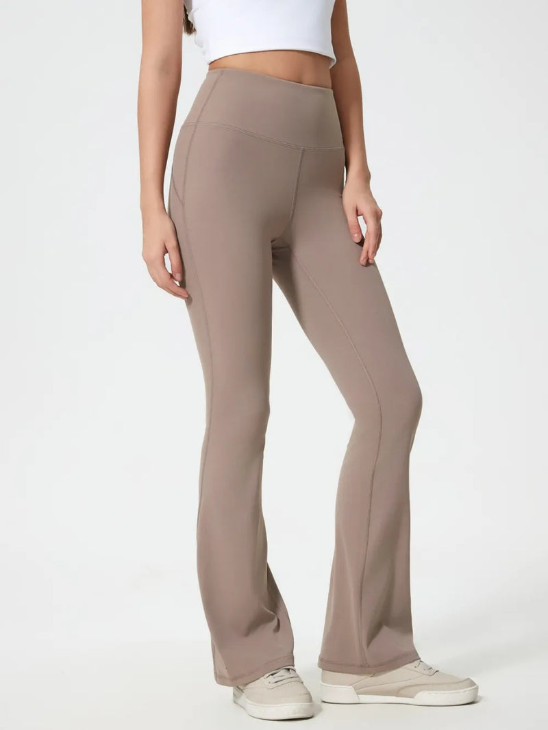 Beige flared pants worn by a person on a white background