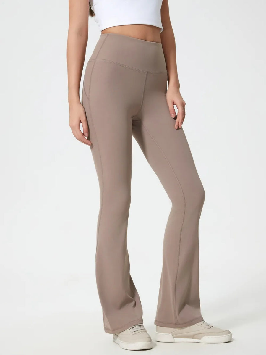 Beige flared pants worn by a person on a white background