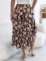 Person wearing a floral skirt sitting on a white couch in a bright room.