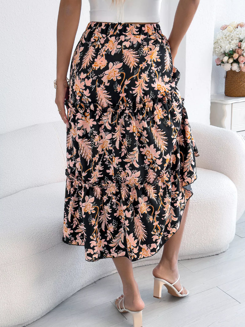 Person wearing a floral skirt sitting on a white couch in a bright room.