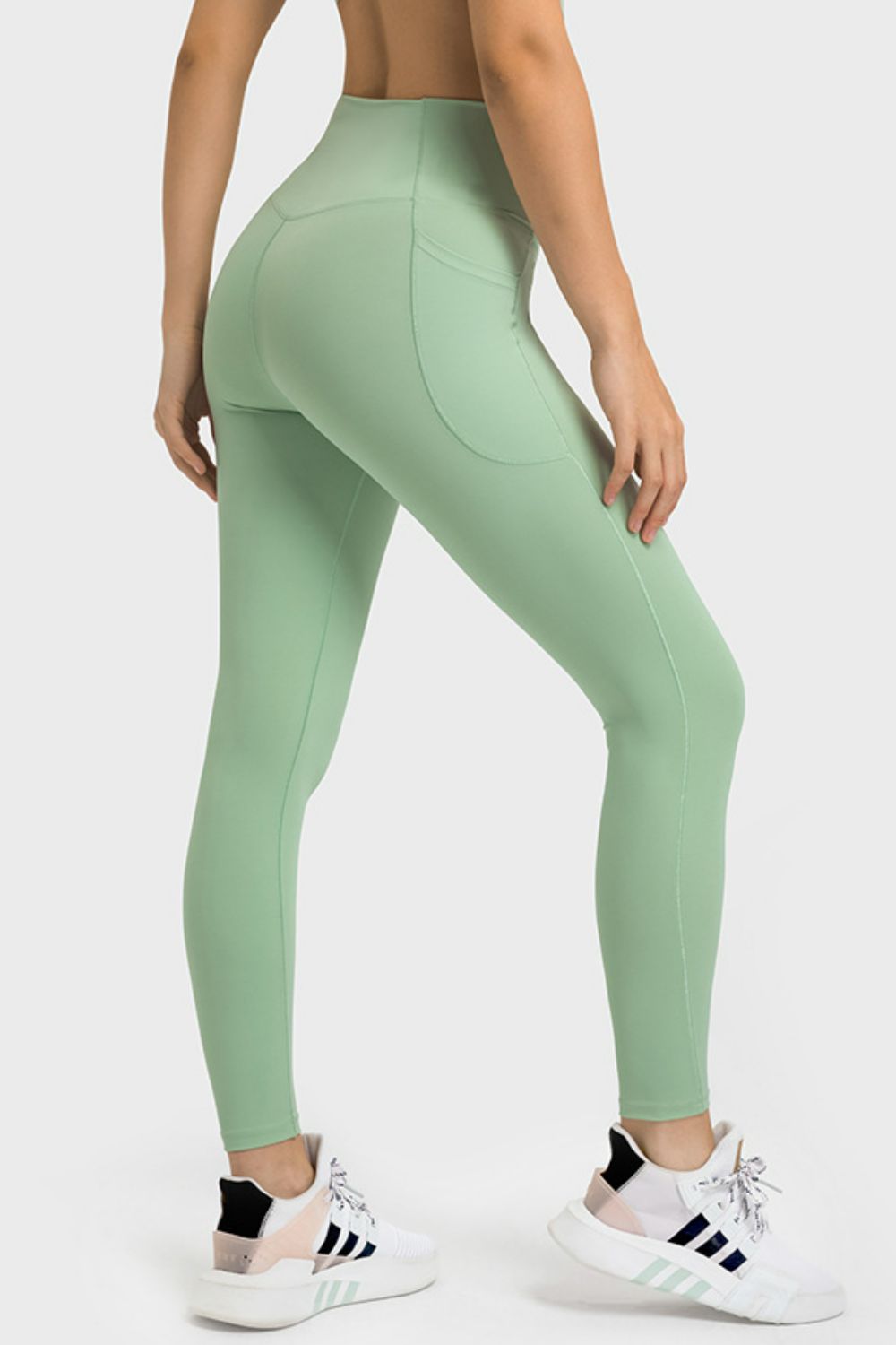 Person wearing green leggings with a white background