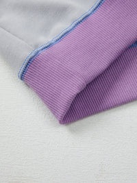 Close-up of a purple fabric edge on a light gray background