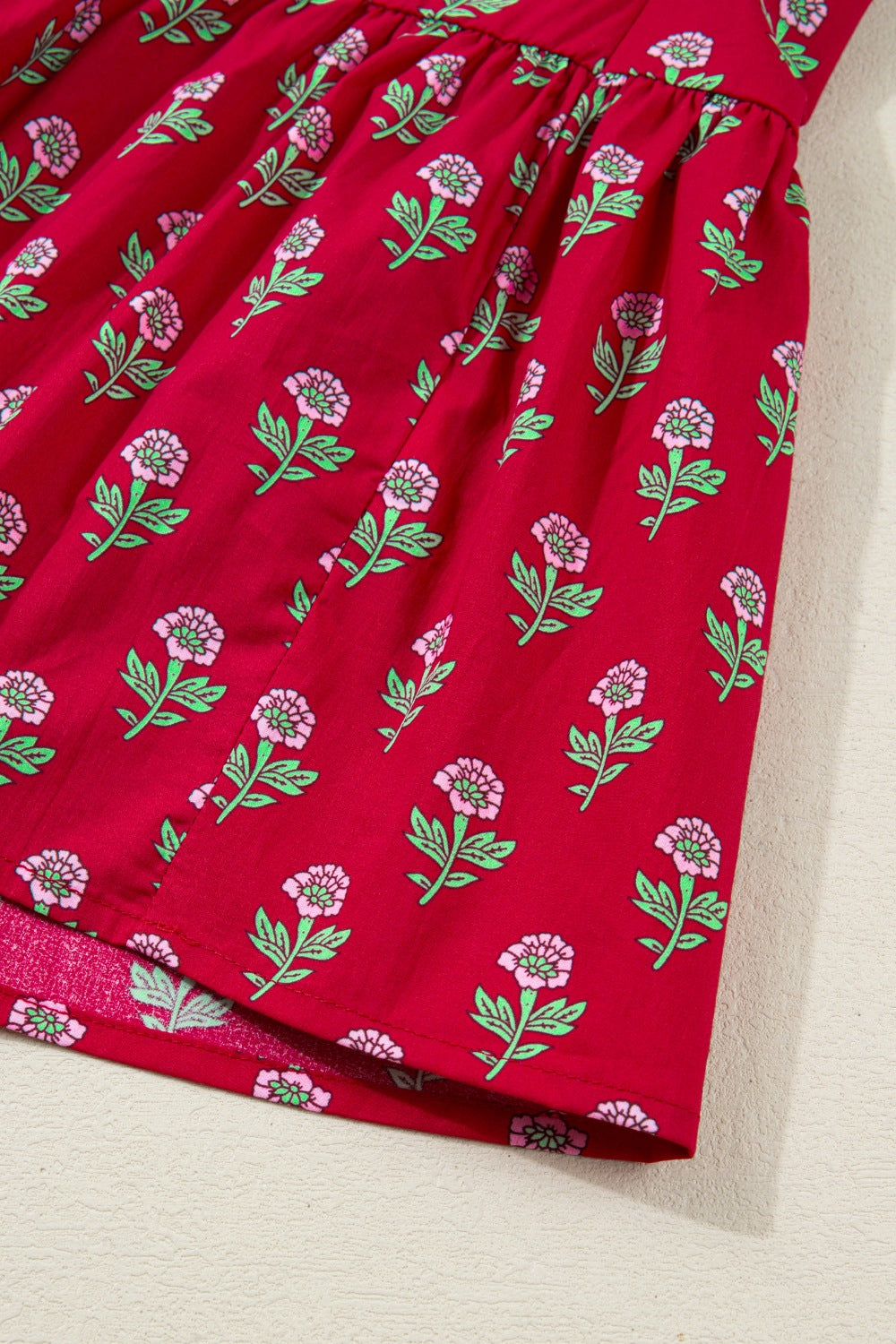 Red fabric with floral pattern on a beige surface