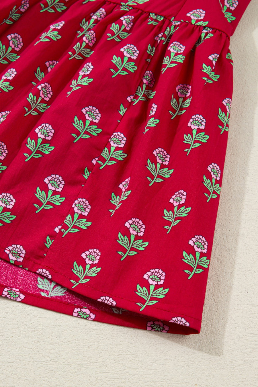Red fabric with floral pattern on a beige surface
