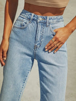 Light blue jeans worn by a person on a neutral background