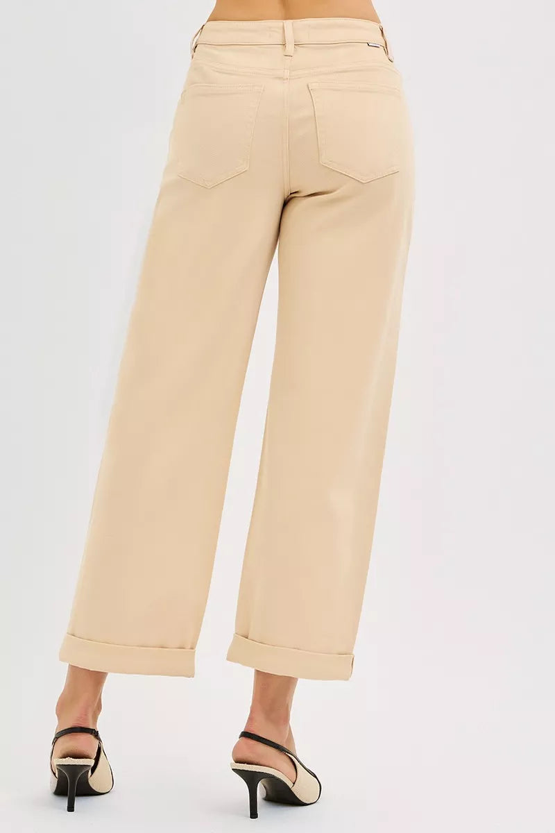 Beige pants worn by a person on a white background