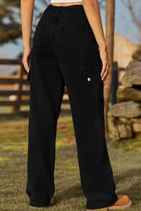 Person wearing black cargo pants standing outdoors with a blurred background