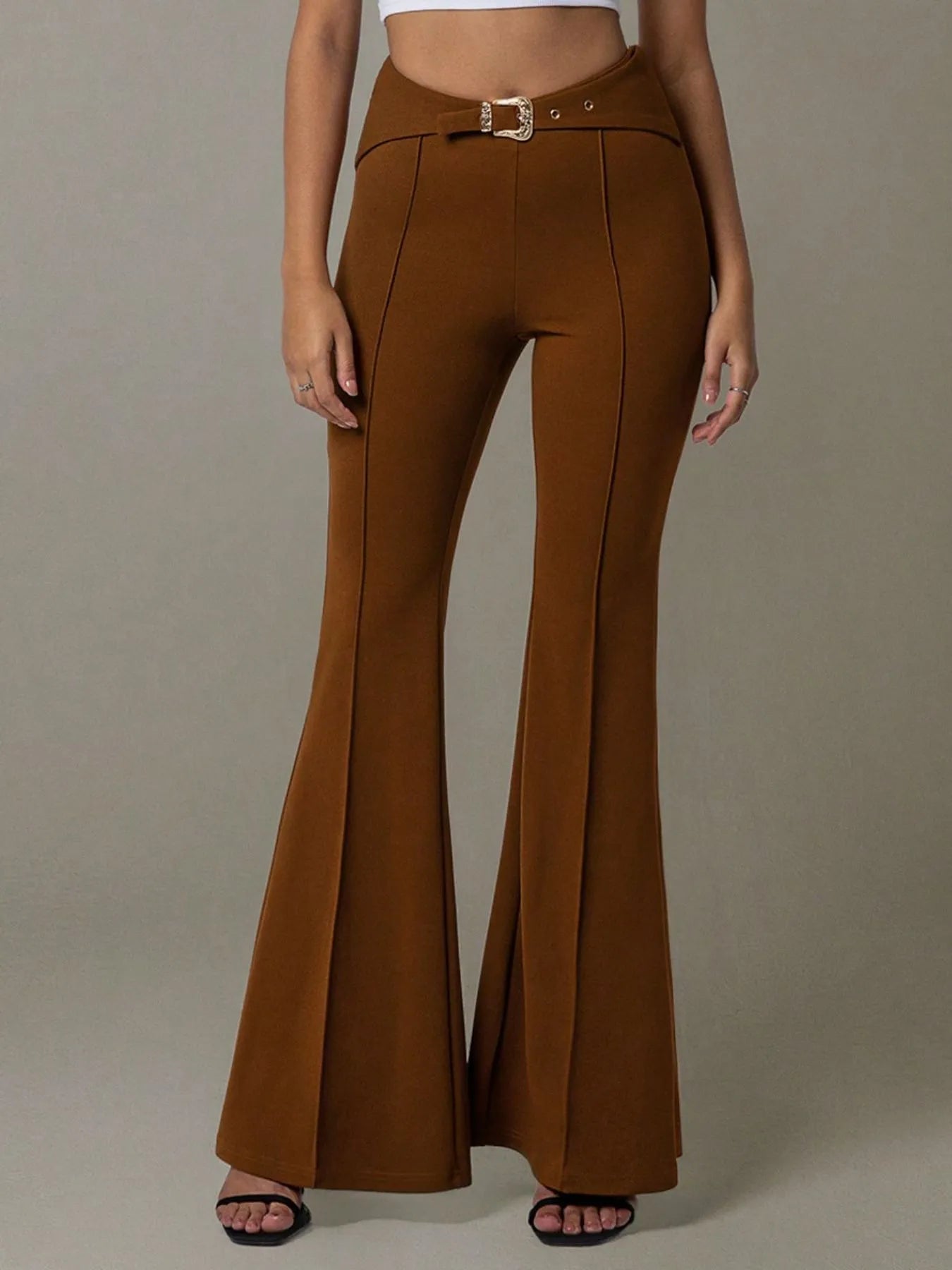 Brown flared pants worn by a person on a plain background