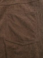 Close-up of brown corduroy fabric with a pocket