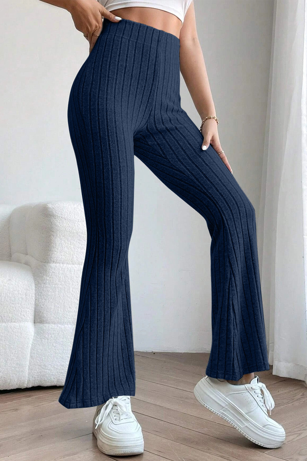 Model posing in blue Basic Bae Full Size Ribbed High Waist Flare Pants
