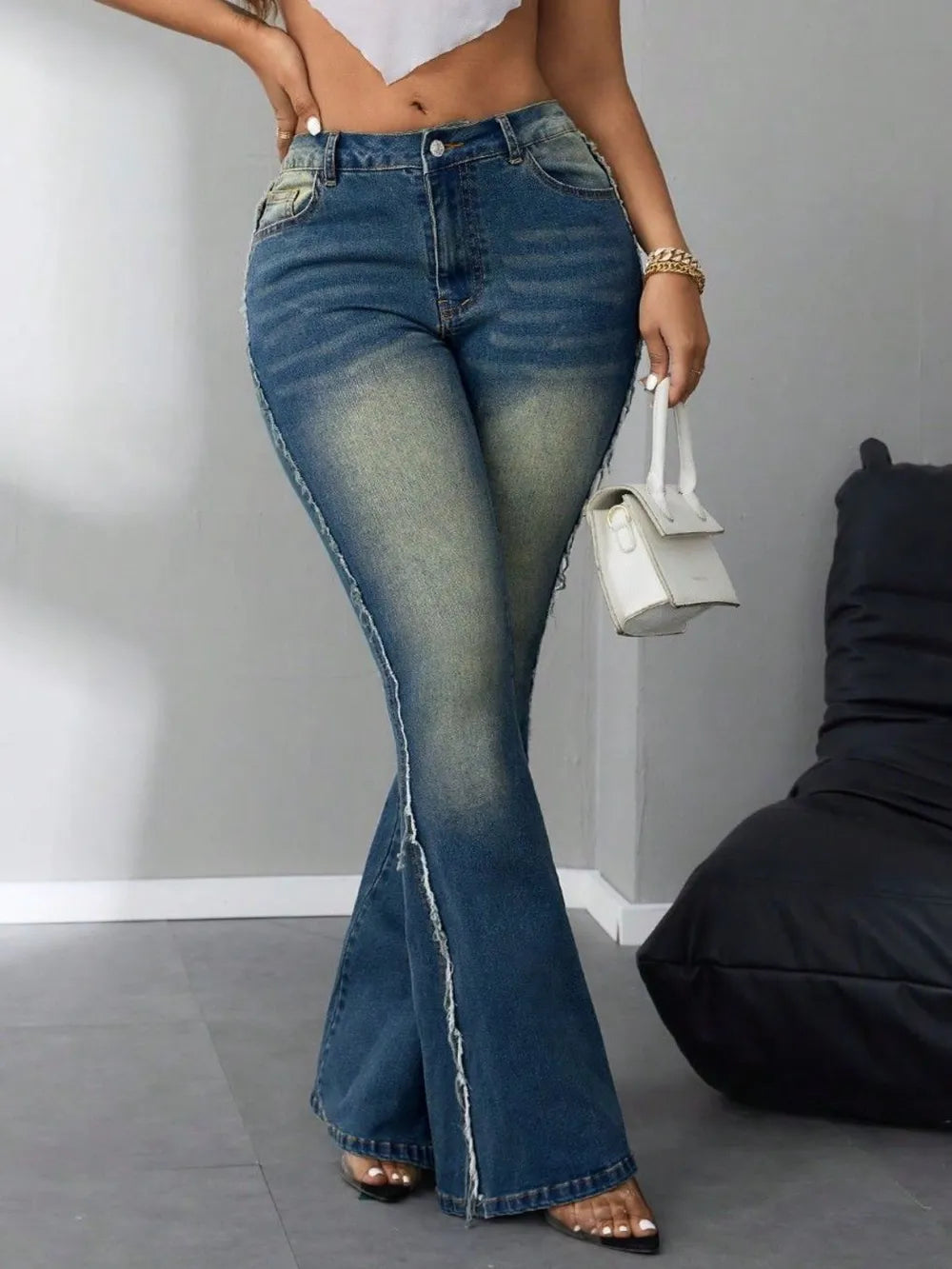 Person wearing blue flared jeans with a plain background