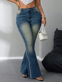 Person wearing blue flared jeans with a plain background