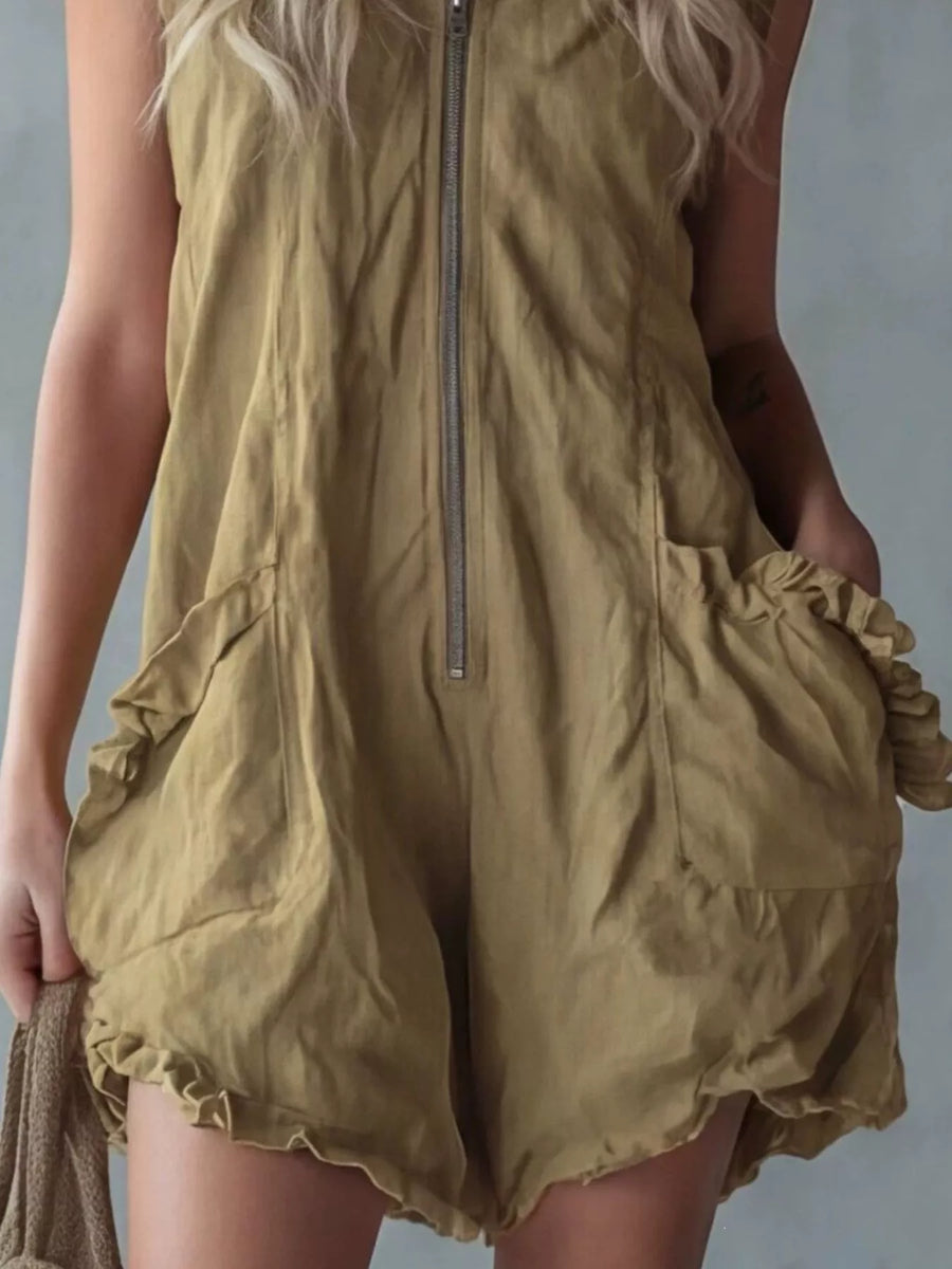 Person wearing a green romper with ruffled details on a plain background