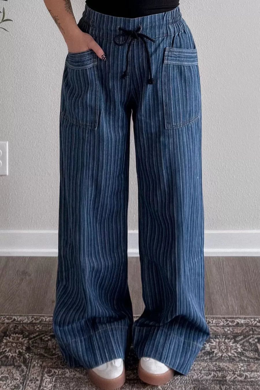 Blue striped pants worn by a person against a neutral background