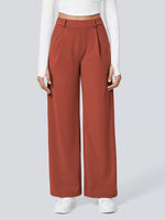 Person wearing rust-colored wide-leg pants and a white top on a light gray background