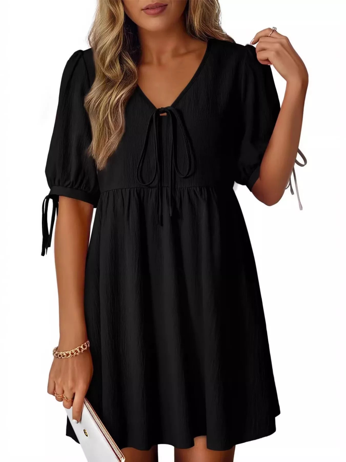 Black dress with puff sleeves worn by a model on a white background