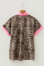 Leopard print dress with pink trim on a hanger against a white background