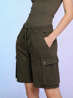 Green cargo shorts worn by a person on a light blue background
